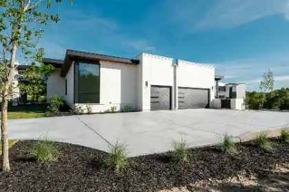 Concrete driveway outside white house with two garage doors | Charleston Concrete
